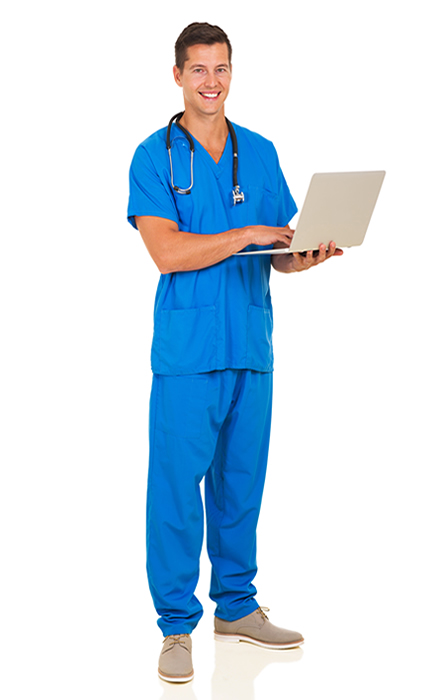 A male doctor or nurse in blue scrubs standing holding a laptop